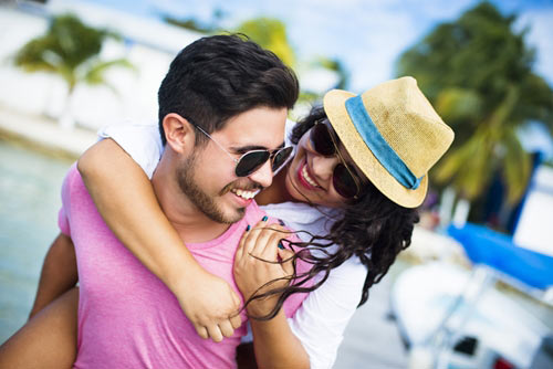 man giving his wife a piggy back ride near a hotel pool